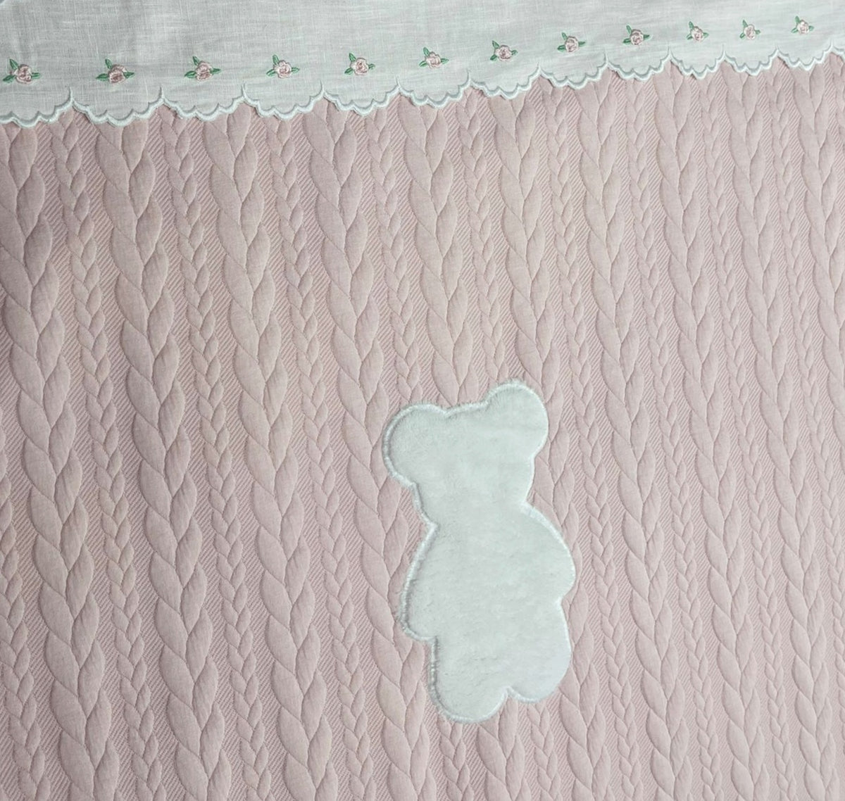 Copertina con trecce rosa e teddy ricamato.
