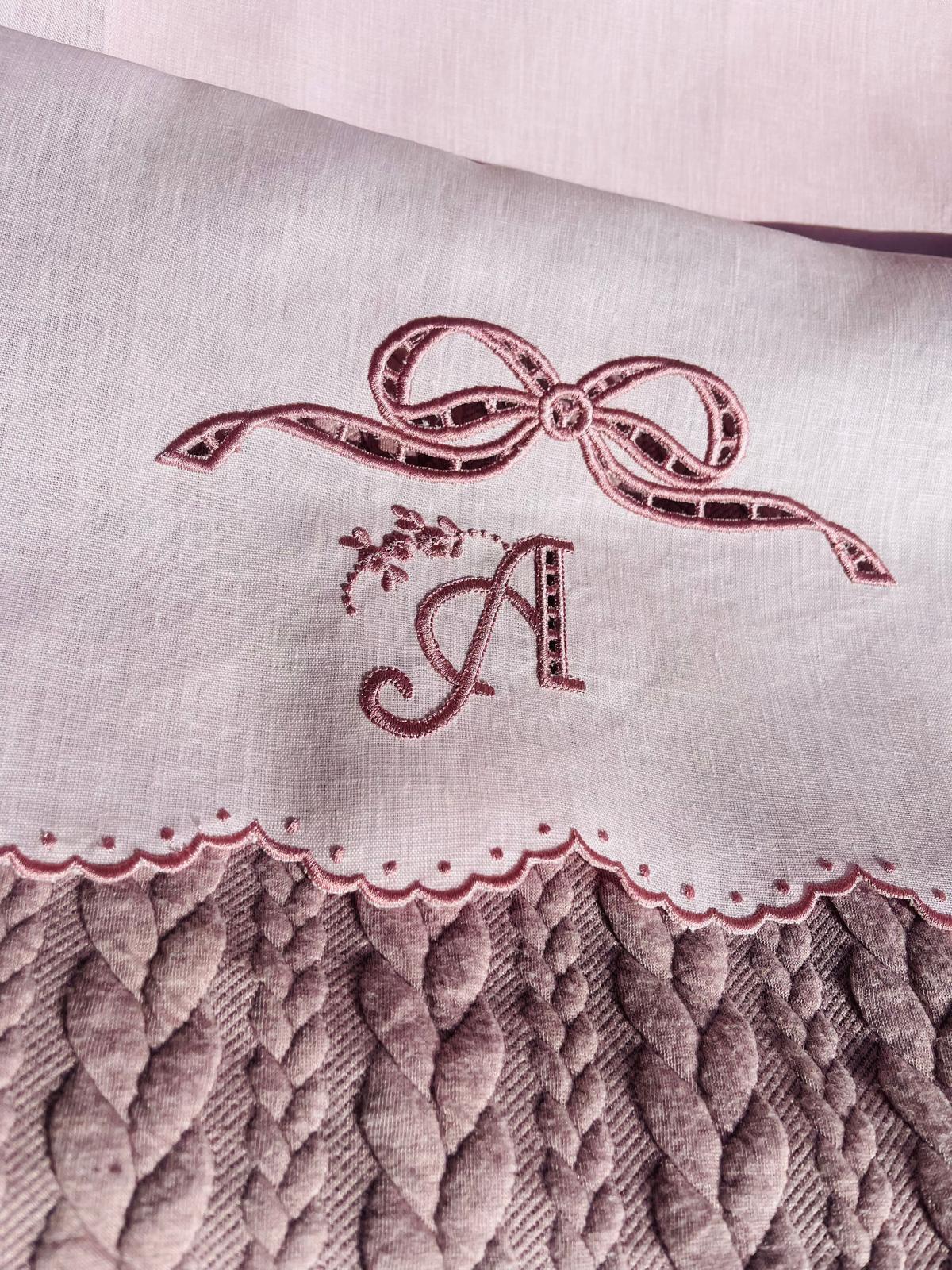 Lenzuolino in lino rosa con fiocco a intaglio e iniziale